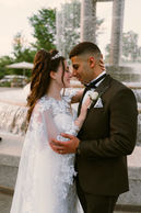 Bride and groom standing close together on a sunlit lawn