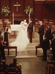 Bride and groom at a church altar decorated with greenery
